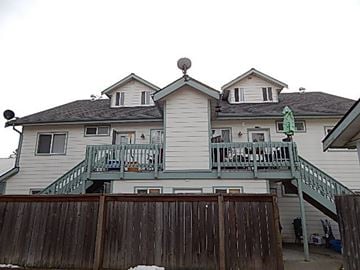 Post Falls house for rent - a white house with a balcony and a fence