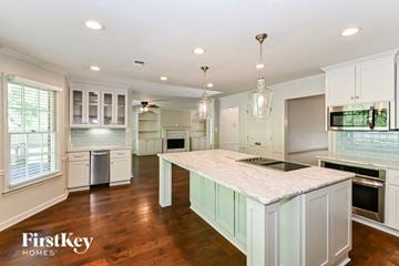 Collierville house for rent - a large kitchen with white cabinets and a marble counter top