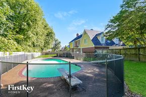 Collierville house for rent - a backyard with a pool and a fence and a house