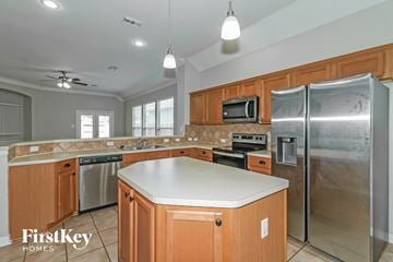 Cypress house for rent - A kitchen with wooden cabinets and a stainless steel refrigerator.