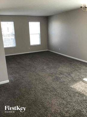 Lancaster house for rent - an empty room with a carpeted floor and two windows