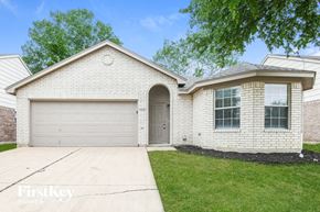Fort Worth house for rent - A brick house with a garage door and a driveway.