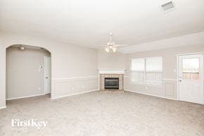 Fort Worth house for rent - A spacious living room with a fireplace and a chandelier.