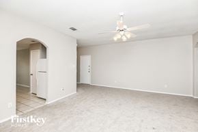 Fort Worth house for rent - A spacious empty room with a ceiling fan and a doorway leading to another room.