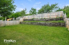 Fort Worth house for rent - A backyard with a wooden fence and a grassy area.