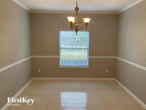 Orange Park house for rent - A room with a chandelier and a window with blinds.