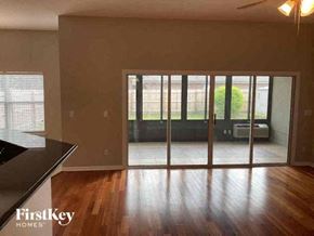 Orange Park house for rent - A room with wooden floors and a sliding glass door leading to a backyard.