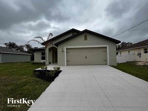 North Port house for rent - a white house with a driveway and a garage door