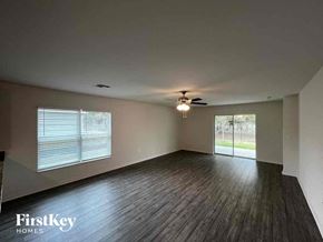 North Port house for rent - an empty living room with wood floors and a ceiling fan