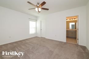 Davenport house for rent - A spacious room with a ceiling fan and a door leading to another room.