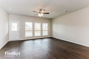 Rosharon house for rent - A spacious room with a ceiling fan and sliding glass doors.