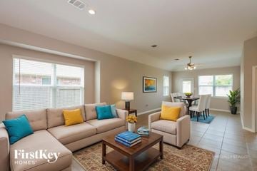 Baytown house for rent - A living room with a beige couch, a coffee table, and a painting on the wall.
