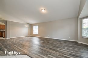 Apopka house for rent - A spacious room with wooden flooring and a large window.