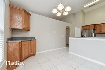 Apopka house for rent - A kitchen with wooden cabinets and a granite countertop.