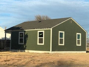 Snyder house for rent - a green house with a dirt field in front of it