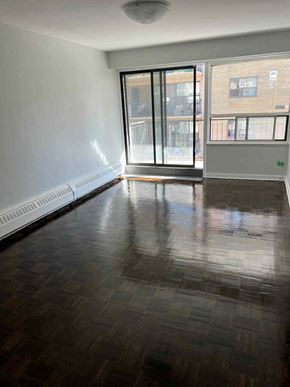 Toronto apartment for rent - an empty living room with a wood floor and a window