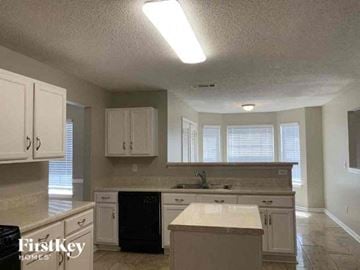 Jonesboro house for rent - a large kitchen with white cabinets and a sink