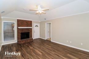 Memphis house for rent - A room with a fireplace and a ceiling fan.
