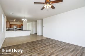 San Tan Valley house for rent - A spacious room with a ceiling fan and wooden flooring.