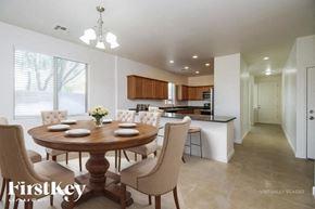 San Tan Valley house for rent - A dining room with a round wooden table surrounded by chairs.