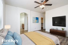 San Tan Valley house for rent - A bedroom with a bed, a ceiling fan, and a painting on the wall.