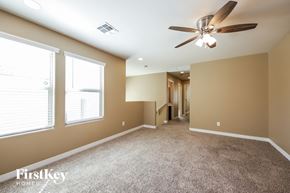Glendale house for rent - a carpeted living room with a ceiling fan and two windows