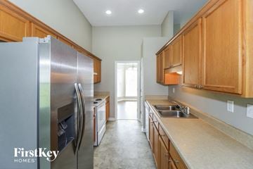Cordova house for rent - a kitchen with stainless steel appliances and wooden cabinets