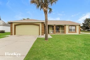 Clermont house for rent - a yellow house with a palm tree in the yard