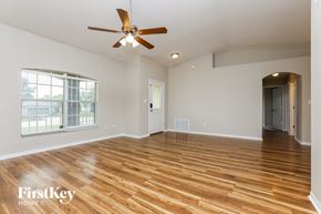 Clermont house for rent - an empty living room with wood floors and a ceiling fan