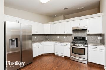 Clermont house for rent - a kitchen with white cabinets and stainless steel appliances