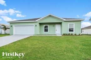 Palm Bay house for rent - A green house with a white garage door and a white front door.