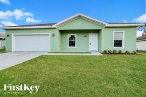 Palm Bay house for rent - A green house with a white garage door and a white door.