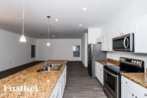 Palm Bay house for rent - A kitchen with granite countertops and stainless steel appliances.