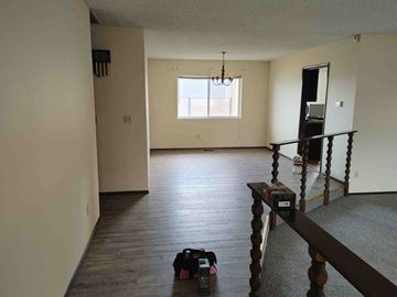 Grandview house for rent - A room with a window and a wooden staircase.