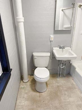 Reading apartment for rent - A white toilet sits next to a sink in a small bathroom.
