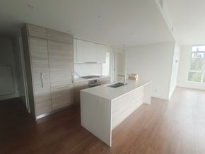 Coquitlam apartment for rent - an empty kitchen with white cabinets and a wooden floor