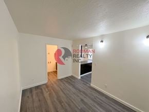 Longview apartment for rent - A room with a wooden floor and white walls, with a doorway leading to another room.