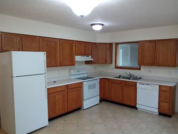 Longview apartment for rent - a kitchen with white appliances and wooden cabinets