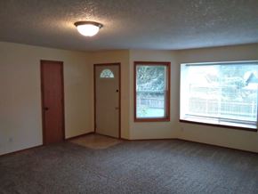 Longview apartment for rent - an empty living room with two windows and a door