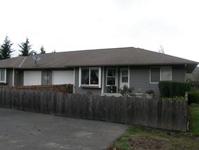 Longview apartment for rent - a gray house with a wooden fence in front of it