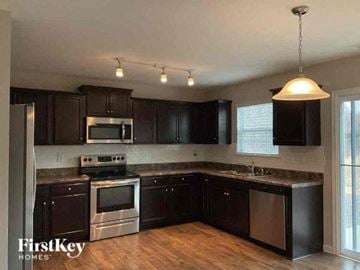 Dallas house for rent - a kitchen with black cabinets and stainless steel appliances