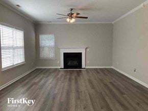 Charlotte house for rent - an empty living room with a ceiling fan and a fireplace