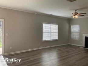 Charlotte house for rent - an empty living room with a ceiling fan and