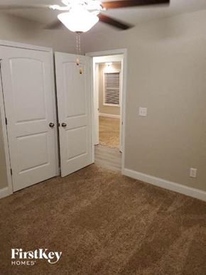 Gainesville house for rent - a bedroom with a closet and a door and a ceiling fan