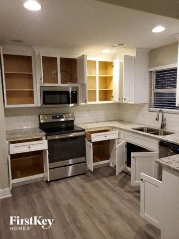 Gainesville house for rent - a kitchen with stainless steel appliances and white cabinets