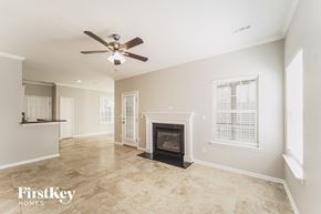 Waxhaw house for rent - a living room with a fireplace and a ceiling fan