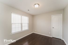 Waxhaw house for rent - a bedroom with wood flooring and a white door and window