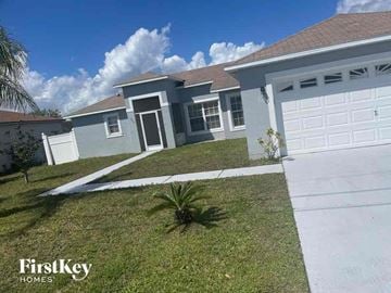 Kissimmee house for rent - a house with a garage and a lawn