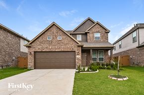 Humble house for rent - A house with a brown garage door is for sale.