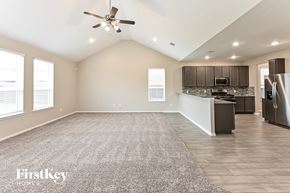 Humble house for rent - A spacious kitchen and living room with a carpeted floor and a ceiling fan.